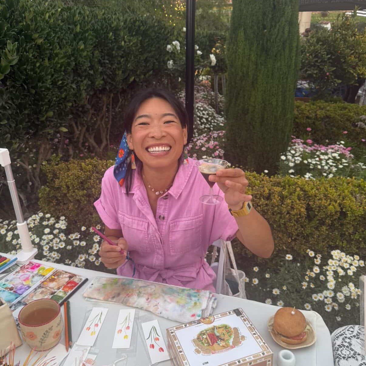 Live illustrator Tiff Chou painting floral bookmarks at a corporate sponsored event